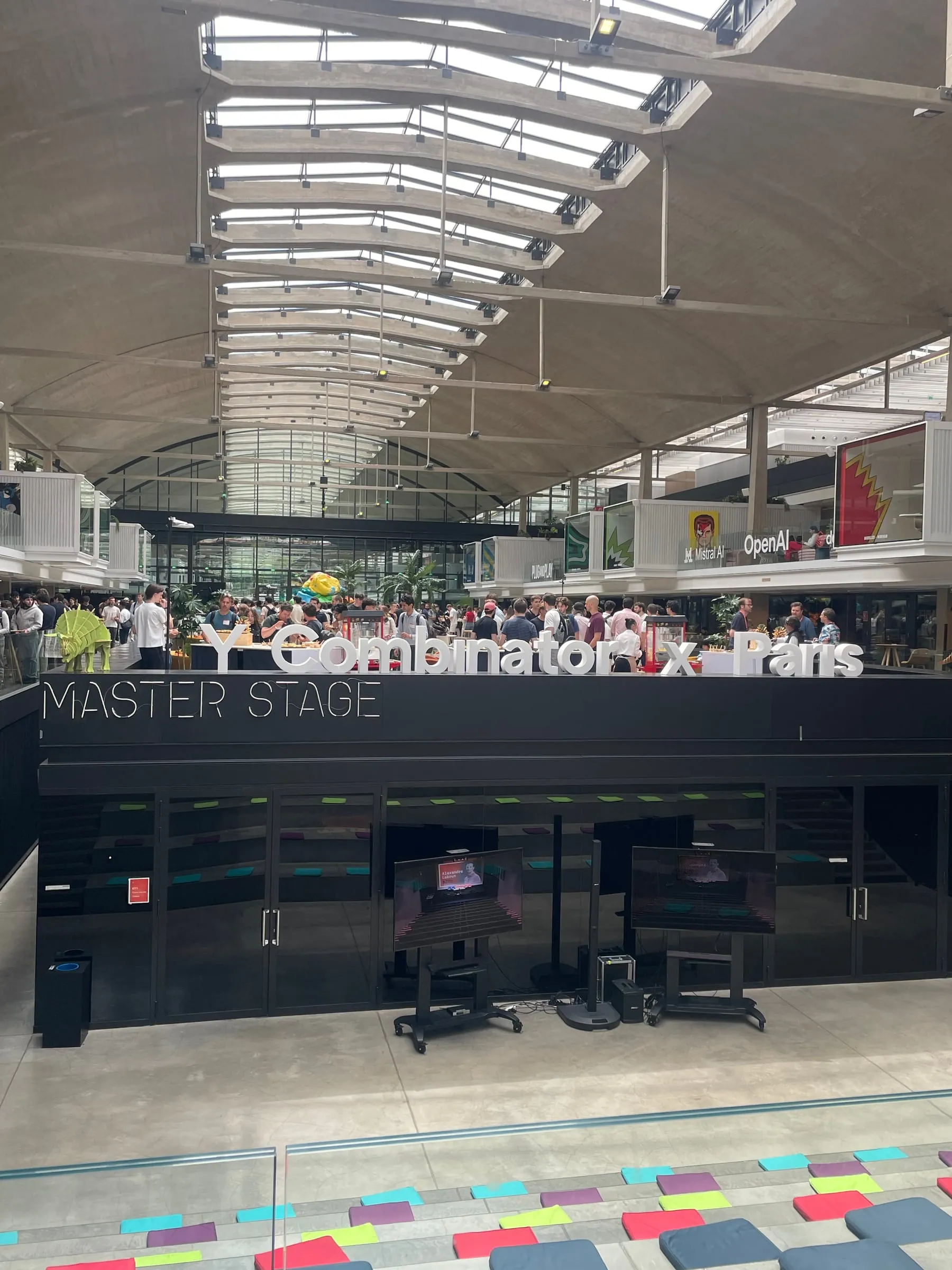 The main hall of STATION F, with the Master Stage and a Y Combinator x Paris sign above the crowd